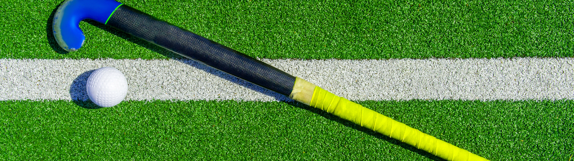 Foto van hockeystick op groen veld